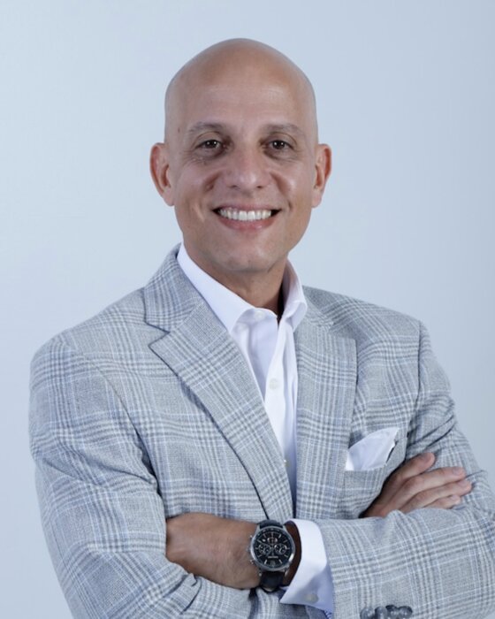 Dr. Alexander A. Bendayan, wearing a light grey checked jacket.
